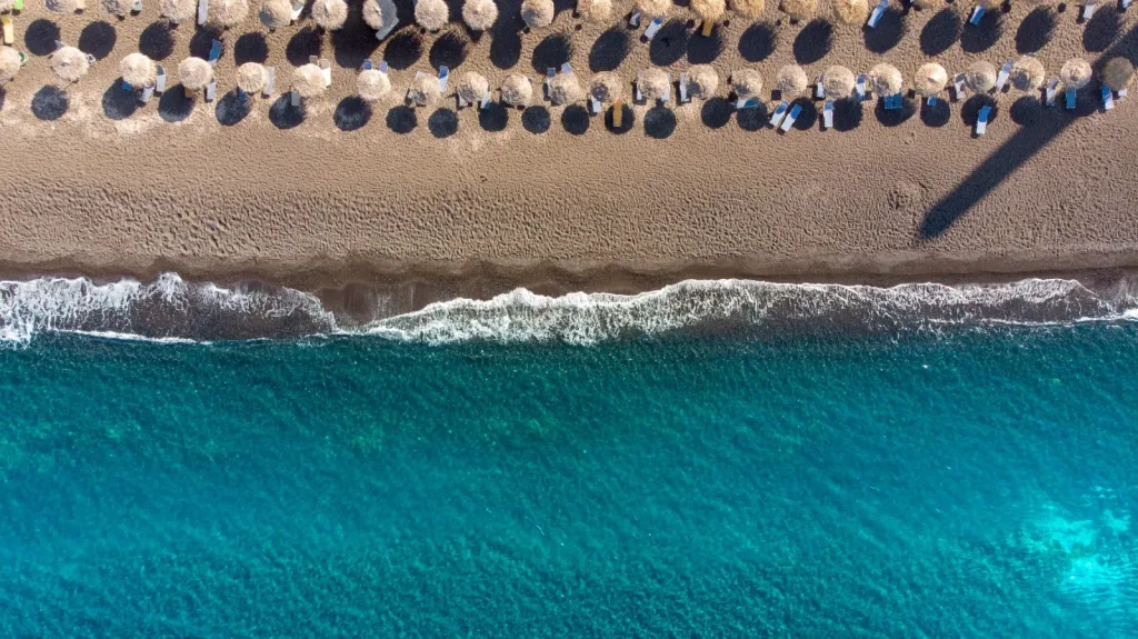Una playa de Santorini a la hora dorada, usada como fondo de la llamada a la acción final