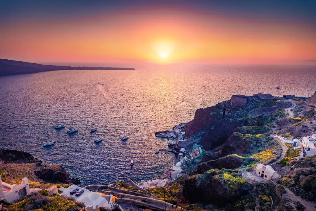 Santorini o zmierzchu, krawędź kaldery rozświetlona na całej długości